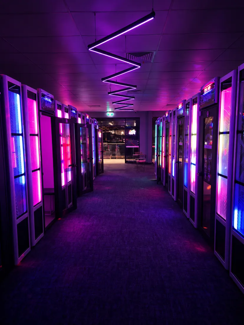 A neon-lit hallway of private booths at On Air